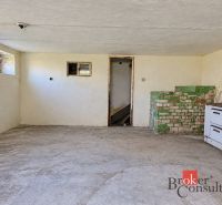 Basement of a family house with a tiled stove and a sink, near Žiar.