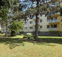 An apartment building with balconies surrounded by greenery on Pred poľom in Trenčín.