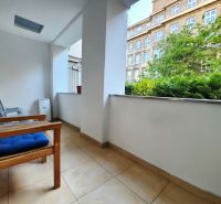 Balcony with a wooden bench, view of the building and greenery, 2-room apartment.