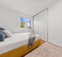 Bedroom in a 3-room apartment with a bed, wardrobe, and laminate flooring.