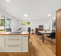 A kitchen with an island and a wooden decor floor in a 3-room apartment.