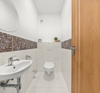 A bathroom with floral tiles and a wall mirror in a 3-room apartment.