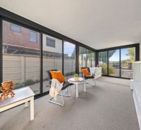 A glazed veranda with comfortable chairs and decorations in a 3-room apartment.