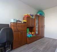 A home office with a computer, cabinets, and a wooden decor floor in a 3-room apartment.