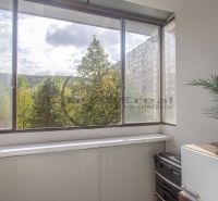 A glazed balcony with a view of greenery and a block of flats in Bratislava - Devínska Nová Ves.