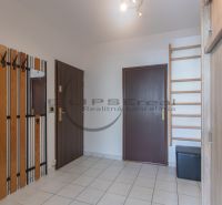Hallway with a coat rack wall, mirror, and tiles in a 3-room apartment.