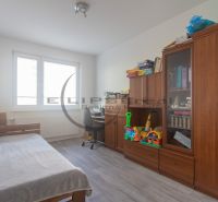 Children's room in a three-room apartment, armchair, sofa, shelf with toys and books.