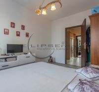 Bedroom in a 3-room apartment with a TV, frames on the wall, and wooden cabinet furniture.