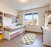 Children's room with a bed, shelves, and a wooden decor floor in a family house.