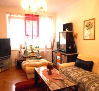 Living room in a two-room apartment with a wooden decor floor and cozy furnishings.