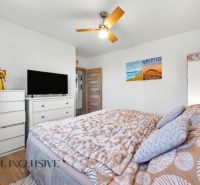 A bedroom in a family house with white furniture, paintings, and decorations.