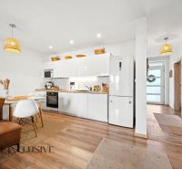 The kitchen and dining room in the family house with a wooden decor floor and white cabinets.