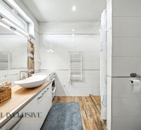 A bathroom in a family house with a modern sink and a floor with a wooden decor.