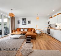 Interior of a family house with a bright kitchen, orange sofa, and a floor with a wooden decor.