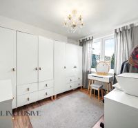 The interior of a family house, a bright room with white cabinets and a floor with a wooden decor.