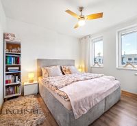 Bedroom in a family house with a bed, bookshelf, and wooden decor flooring.