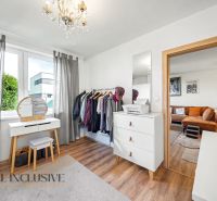 A room in a family house with a dressing table, wardrobe, and a floor with a wooden decor.