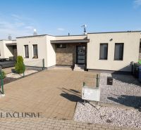 A family house in Oľdza with two cars, a landscaped garden, and paving.