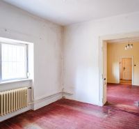 A room in a family house with a window, radiator, and floor with a wooden decor.