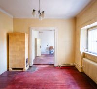 Interior of a family house with a tiled stove and a wooden decor floor.