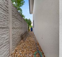 The exterior of a family house on Vážska Street in Trenčín with a gravel path and a fence.