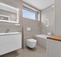 A bathroom in a family house with simple furnishings and a dominant mirror above the sink.