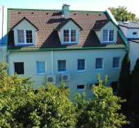 A building with a sloped roof and a garden on Kladnianska Street in Bratislava - Ružinov. Offices.