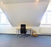 An office with a desk, chair, and cabinet, featuring skylights.