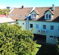 A building with a brown roof and trees in Bratislava - Ružinov on Kladnianska Street, Offices.