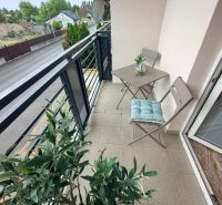 The balcony of a 3-room apartment with a plant and furniture overlooking Veľkoblahovská Road in Dunajská Streda.