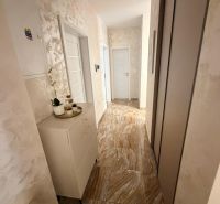 Interior of a 3-room apartment with tiles and cabinets in the hallway.