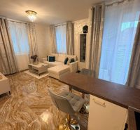 A living room in a three-room apartment with tiles and a light sofa, accessories in turquoise.