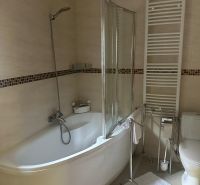 A bathroom with a bathtub, a white ladder, and tiles in a 3-room apartment.