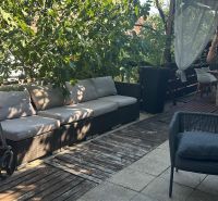 A terrace with comfortable seating, wooden flooring, and greenery in a 3-room apartment.