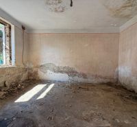 Abandoned room with damaged walls and a window in a family house.