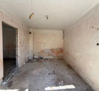 A room in a family house before renovation with exposed walls and floor.