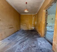 A room in a family house with a concrete floor and orange walls.