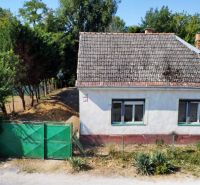 A family house on St. Florian Square in Krakovany, surrounded by greenery and a fence.