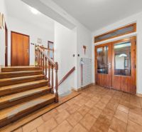 Interior of a family house with a staircase, tiles, and wall decorations.