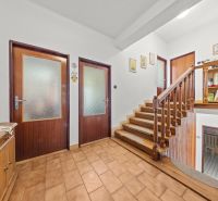 A hallway of a family house with wooden railing and wall decorations.
