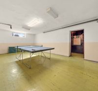 A ping pong table in a family house on a floor with a wooden decor.