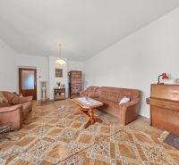 Living room in a family house with a leather sofa, piano, and wooden decor flooring.