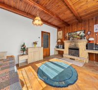 Interior of a family house with a fireplace, wooden decor flooring, and a carpet.