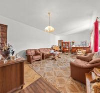 Living room in a family house with a wooden decor floor, comfortable leather sofas.
