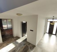 Interior of a family house with large tiles and entrance doors.