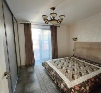A bedroom in a family house with a large bed, cabinets, and an elegant chandelier.