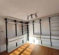 A wardrobe in a family house with shelves, drawers, and a wooden decor floor.