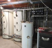 Technical equipment in a family house with a boiler and a furnace, pipes across the room.