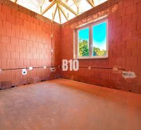 Interior of a family house in Čeľadice with brick walls and a fitted window.
