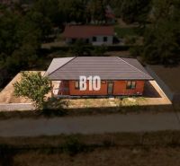 A family house in Čeľadice with a brick facade, a sloped roof, and fencing.